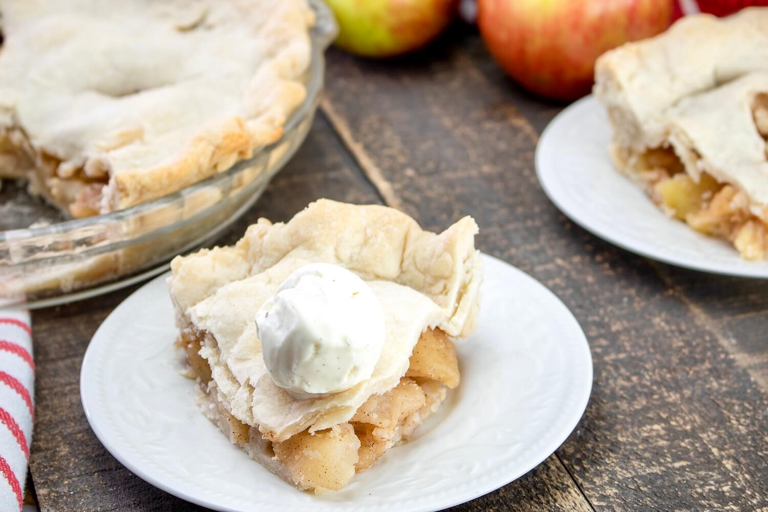 Slice of Apple pie on saucer with ice cream on top